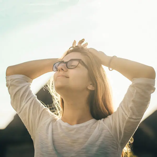 Woman with hands on head breathing in